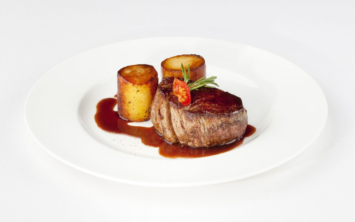 10997379 - beef filet with fondant potato and red wine sauce on a white plate bordelaise